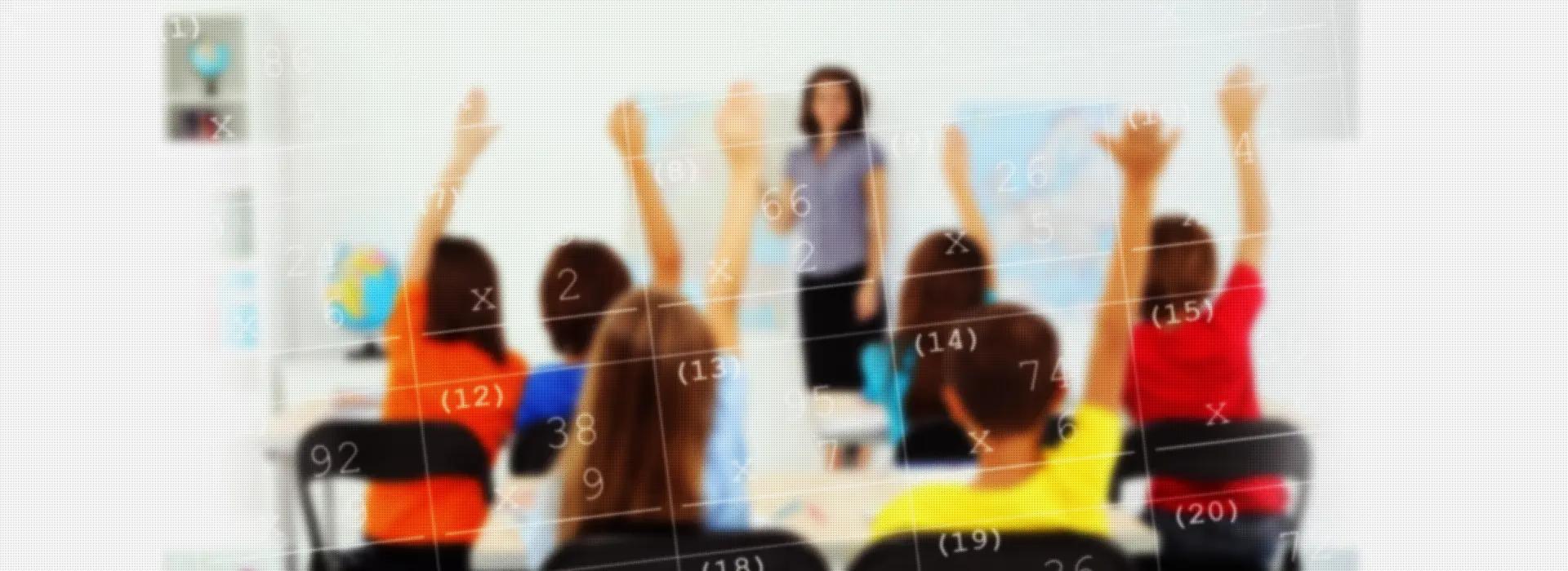 Image showing a classroom of students with their hand raised and a female teacher in front of a whiteboard. 