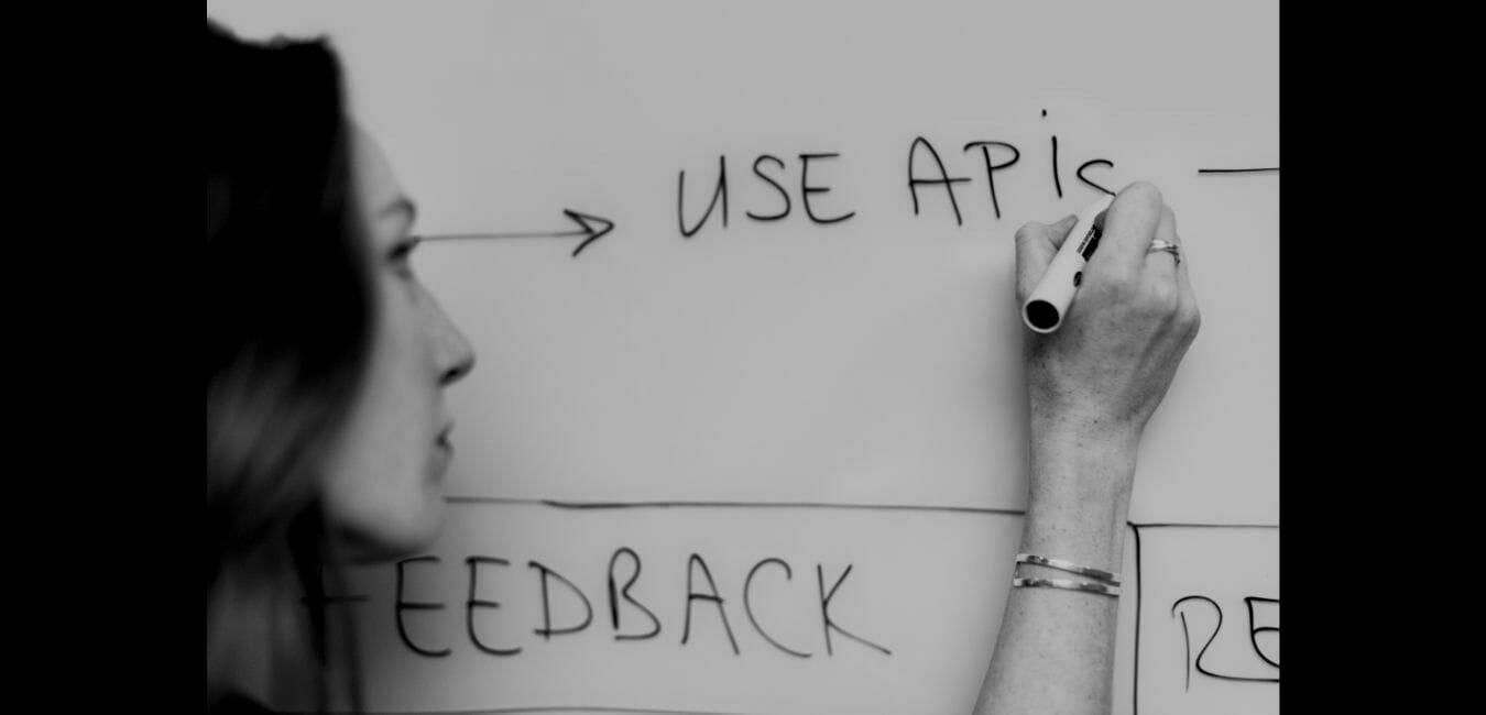 Lady-Writing-on-White-Board-about-API-darken