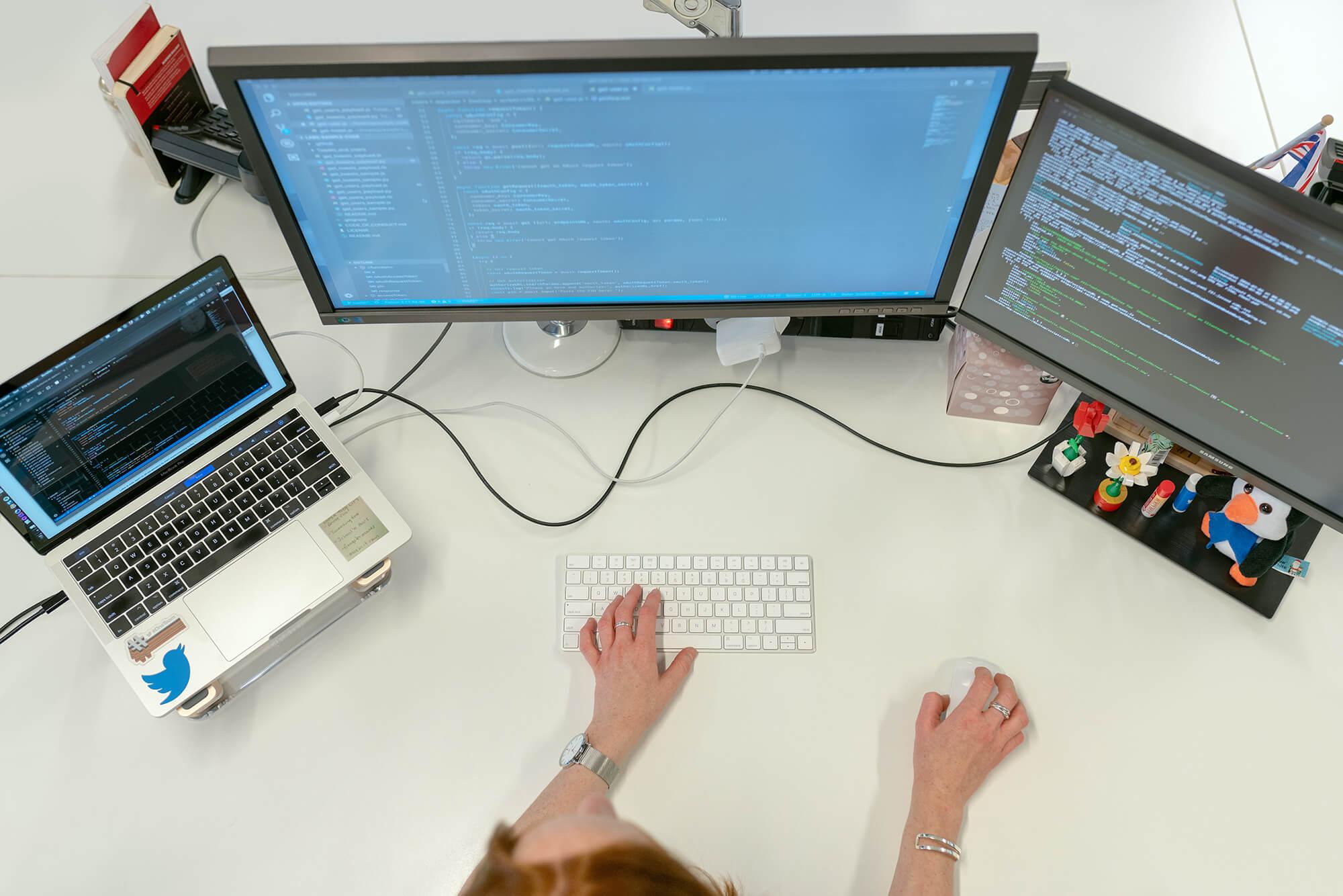 Overview of person's desk and her computer monitors turned on.
